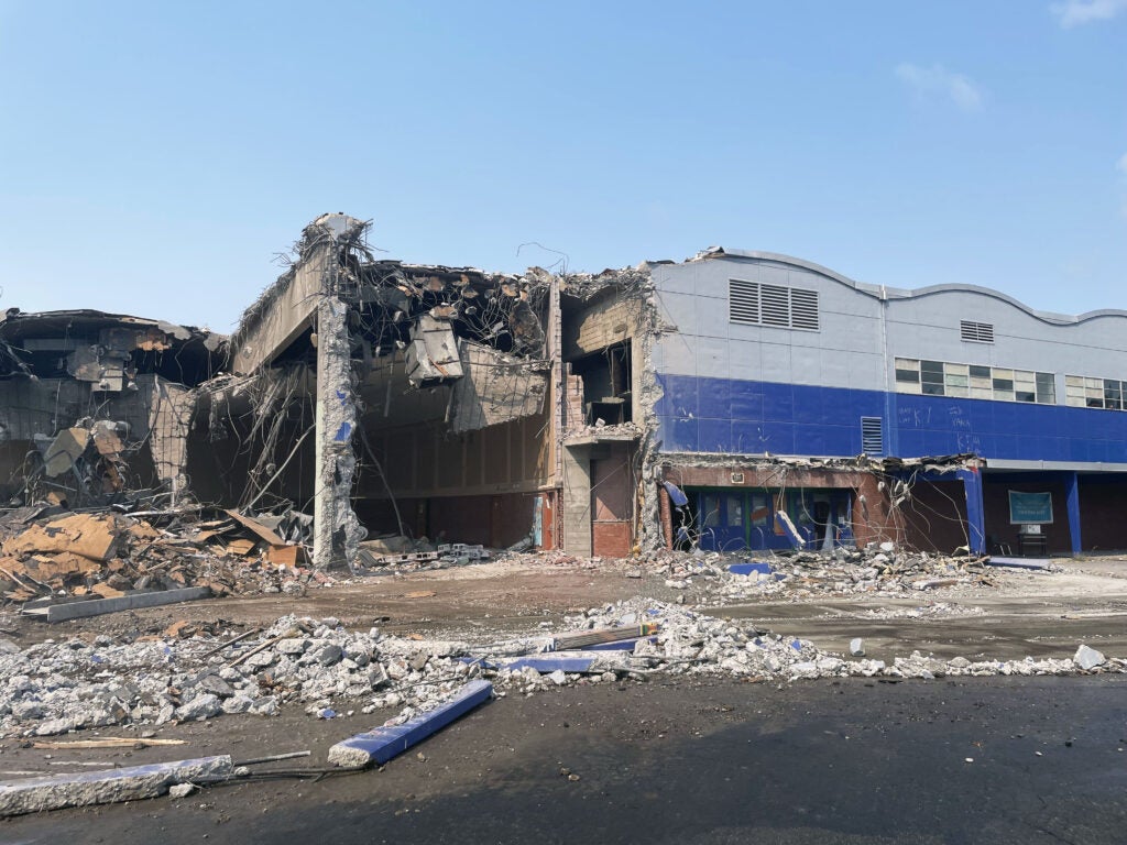 a partially demolished building. the remaining part of the building is two stories with a series of arched roofs