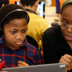 Volunteer working with student on Hour of Code