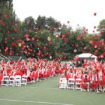 Ballard High School Grads throw caps during graduation ceremony.