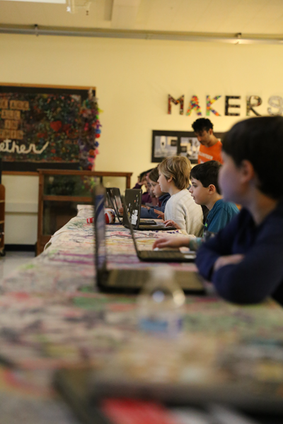 students working at laptops in a classroom