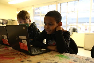 students working at laptops in a classroom