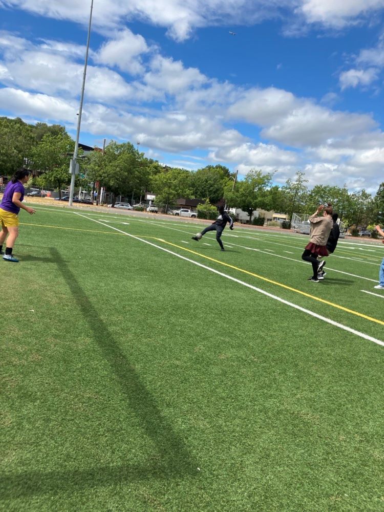 Students playing soccer with teacher