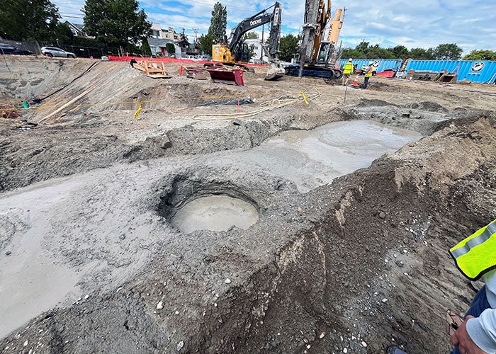 a large round hold filled with water in a dirt construction site