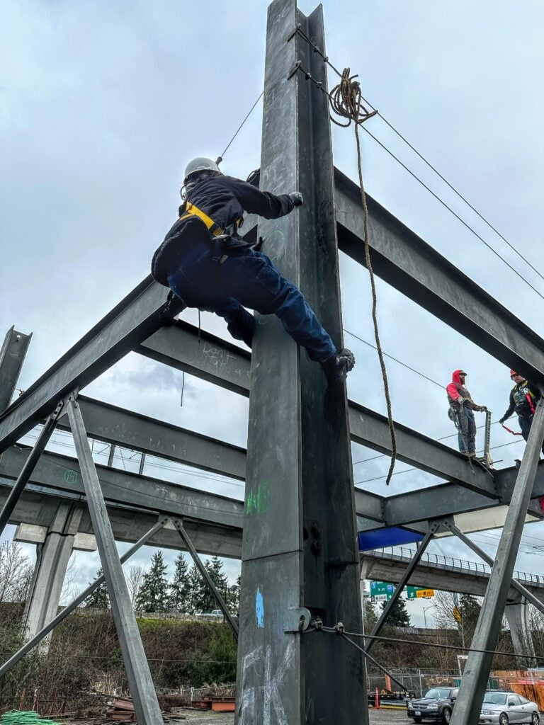 Image of student climbing building during pre-apprenticeship for iron work