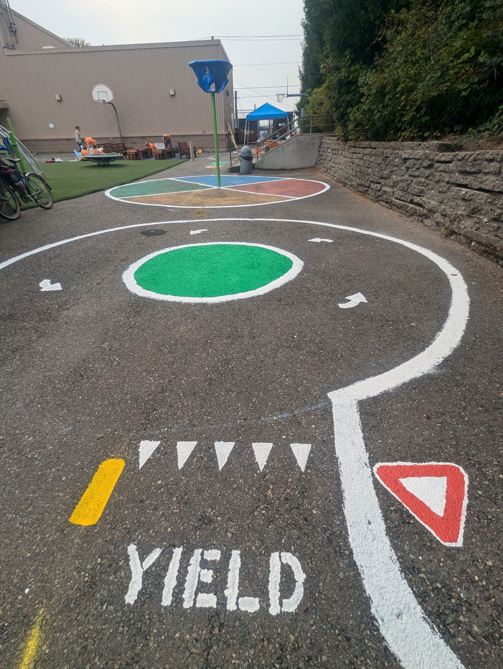 Miniature street painted with yield and roundabout.