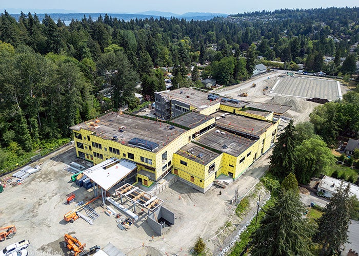 a building under construction with trees in the background