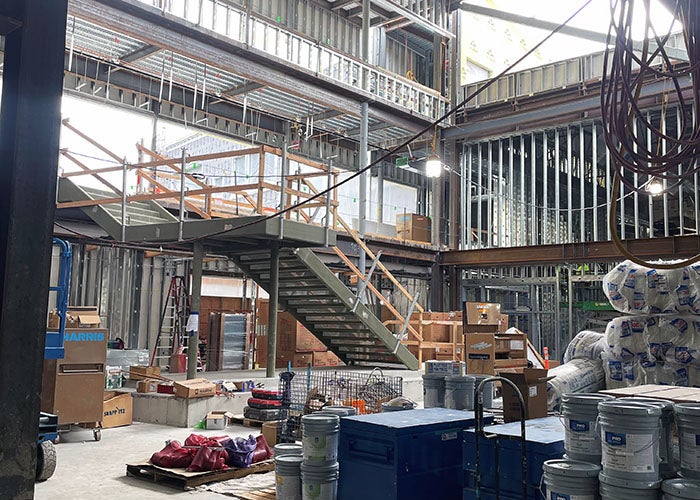 interior of a building under construction with materials on the ground floor and stairs leading up