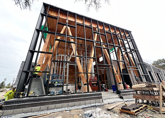 metal framing in front of cross laminated timber bracing and ceiling for a two story building under construction