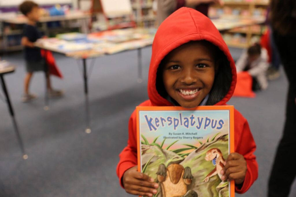 A smiling boy holding a book