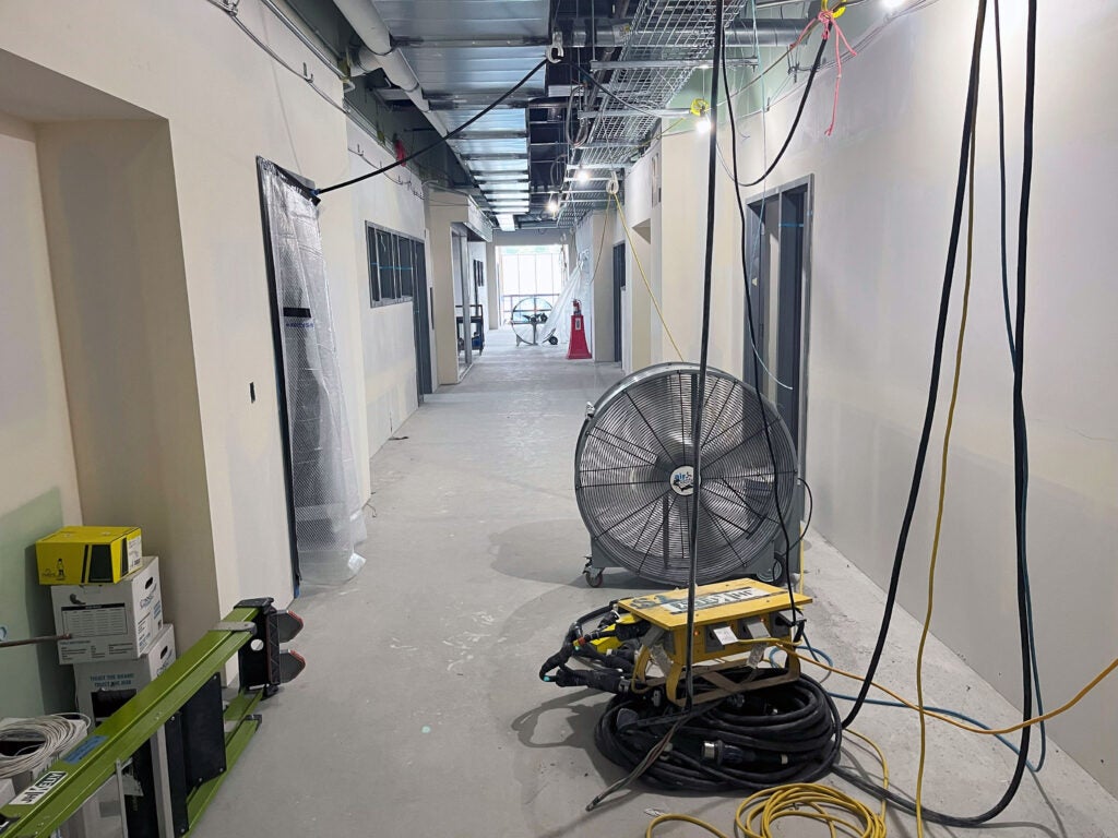 a hallway under construction with a large fan on the floor