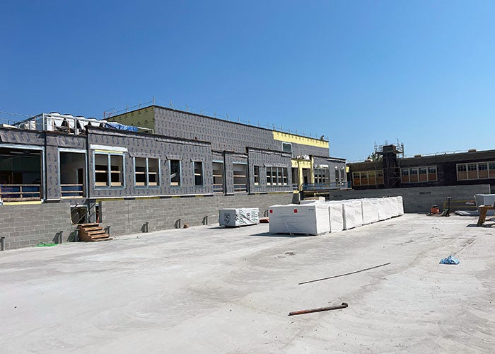 a flat roof with some materials and a building on one side