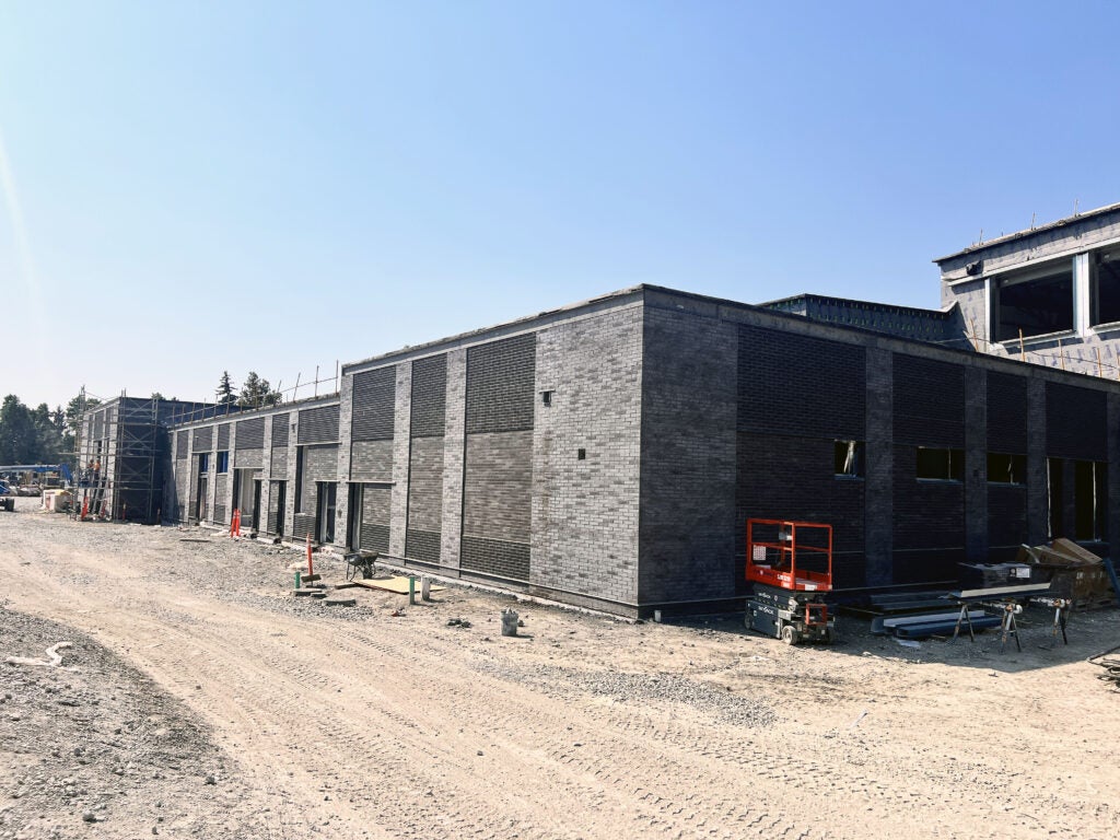 a gray brick building with dirt around it