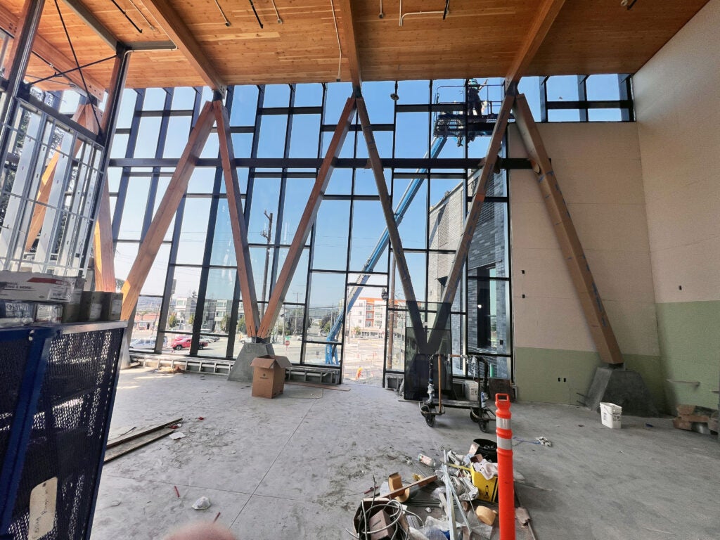 interior looking out through 2 story wall of windows with timber braces set in triangles