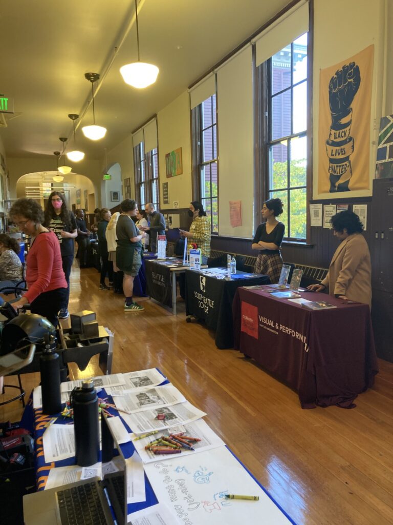 Tables lining hallway of high school with colleges representatives