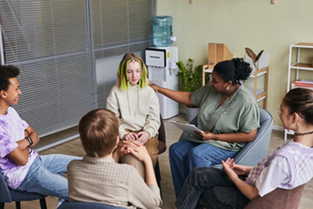 A student is shown with a support group of their peers.