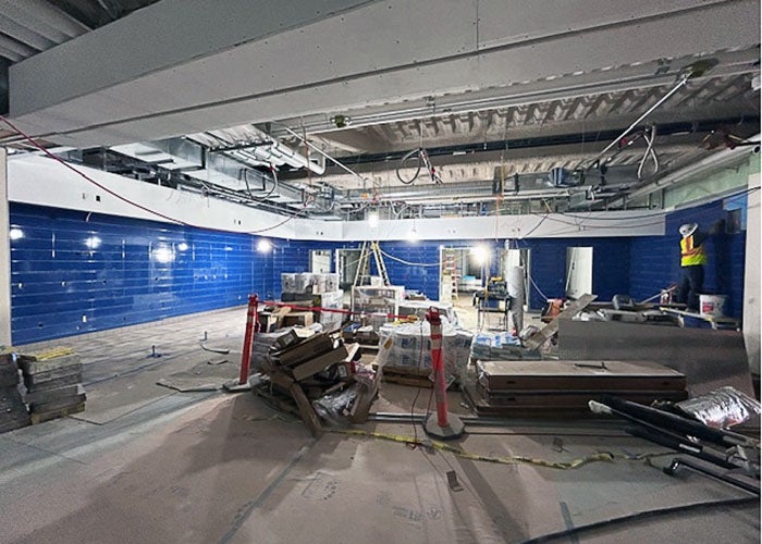 a large space under construction with blue tiles on the wall and construction materials in the room