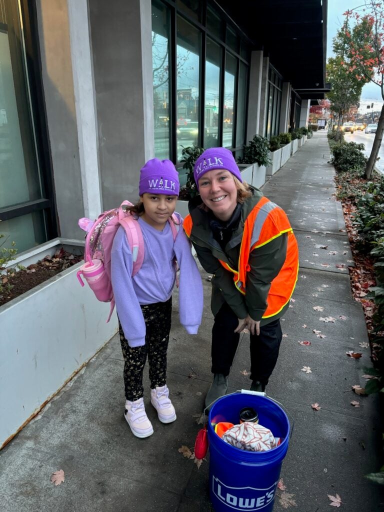 Student and adult with purple Ruby Bridges Day hats on their walk to school.