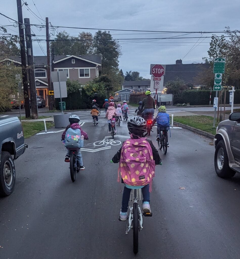 Group of student bikers on neighborhood street.