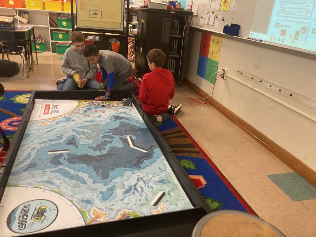 Students examine first lego league robotics obstacle course