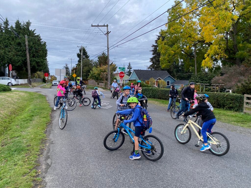 Group of student bikers on neighborhood street.