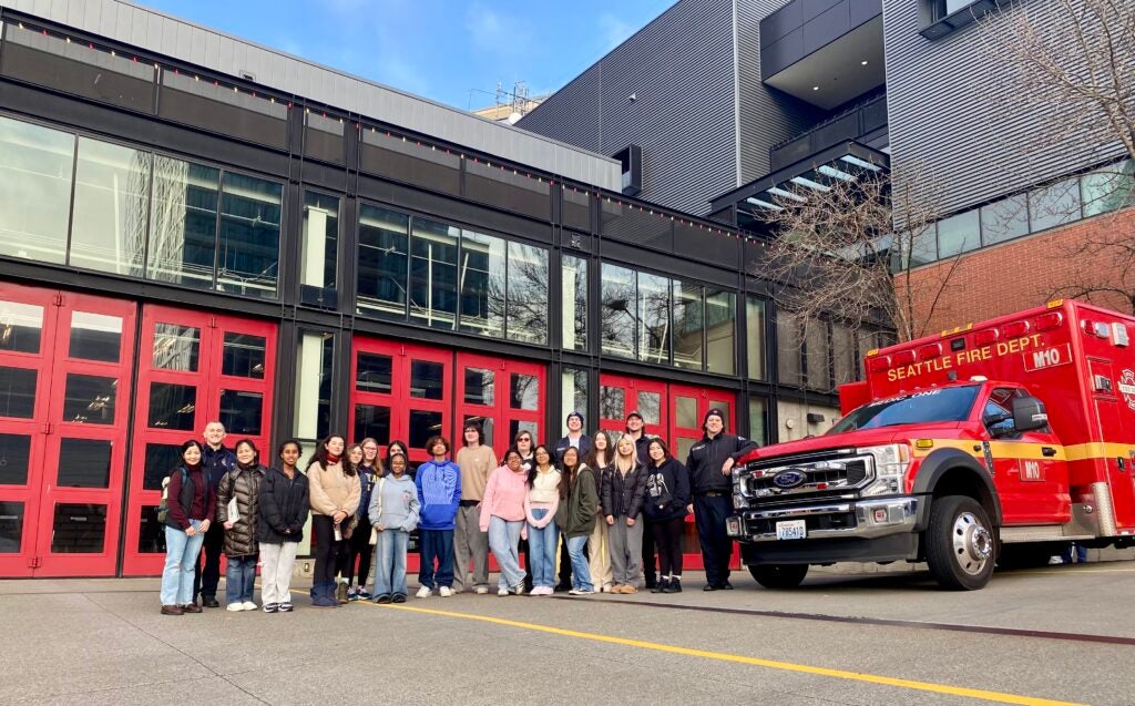 Students standing in front of fire station and fire truck during field trip