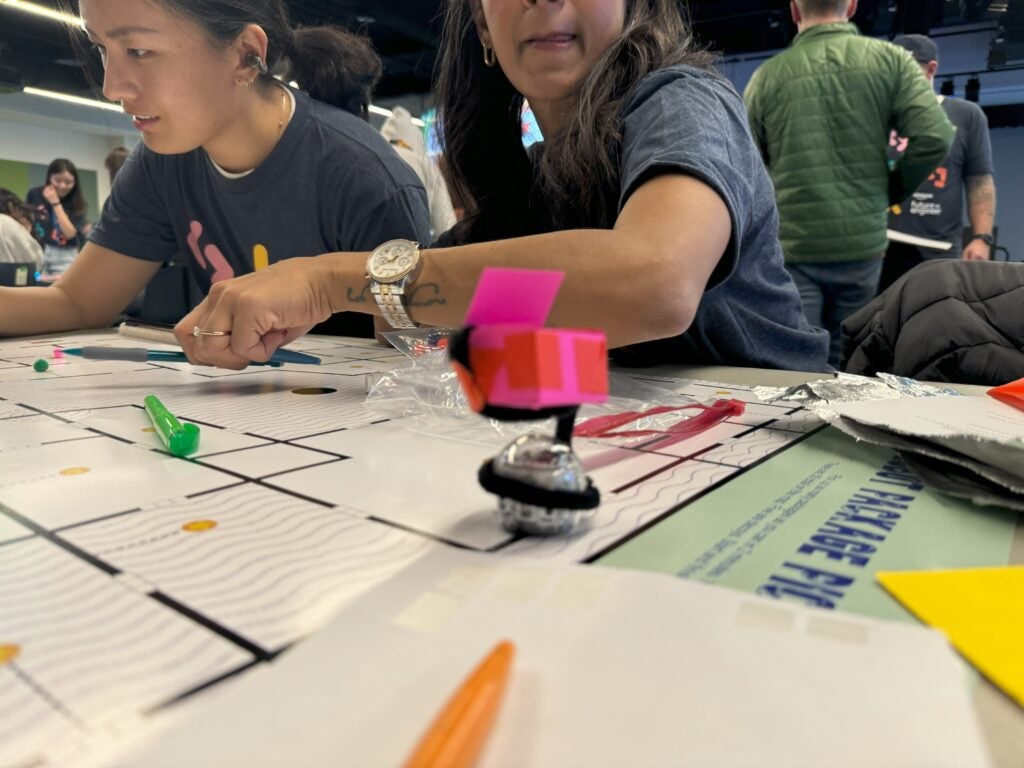 Teacher and student leaning over obstacle course for ozobot