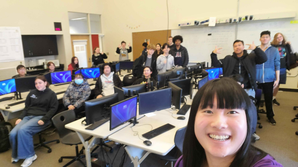 Students pose for a selfie with a UW representative after a session on machine learning