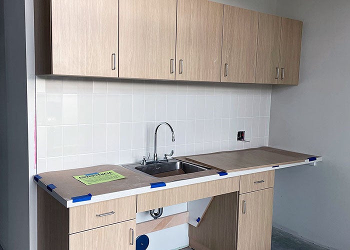 a sink and cabinets with a tile backsplash