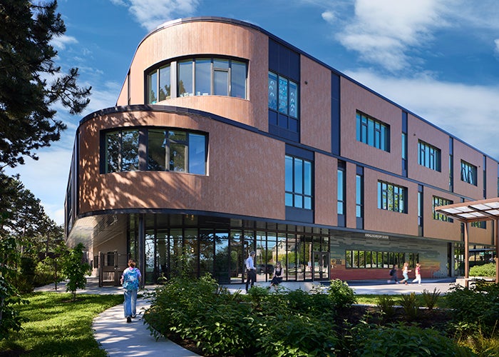 part of a 3 story building with a curved end and windows