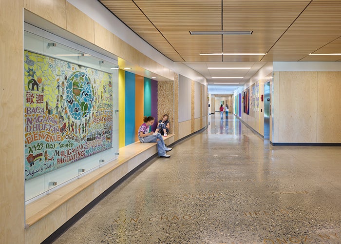 a hallway with a bench and a mural