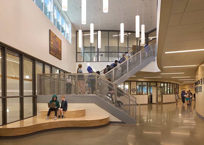 a large space with high ceilings and a stairway with lights hanging down