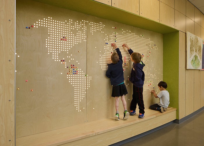 children in a nook in front of a map