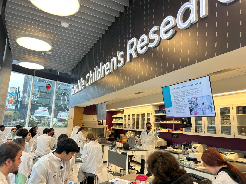 Students wearing white lab coats in health and medical research lab