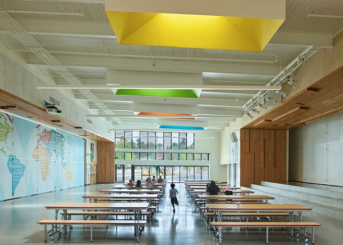 a lunchroom with a stage on one side and a map on the other