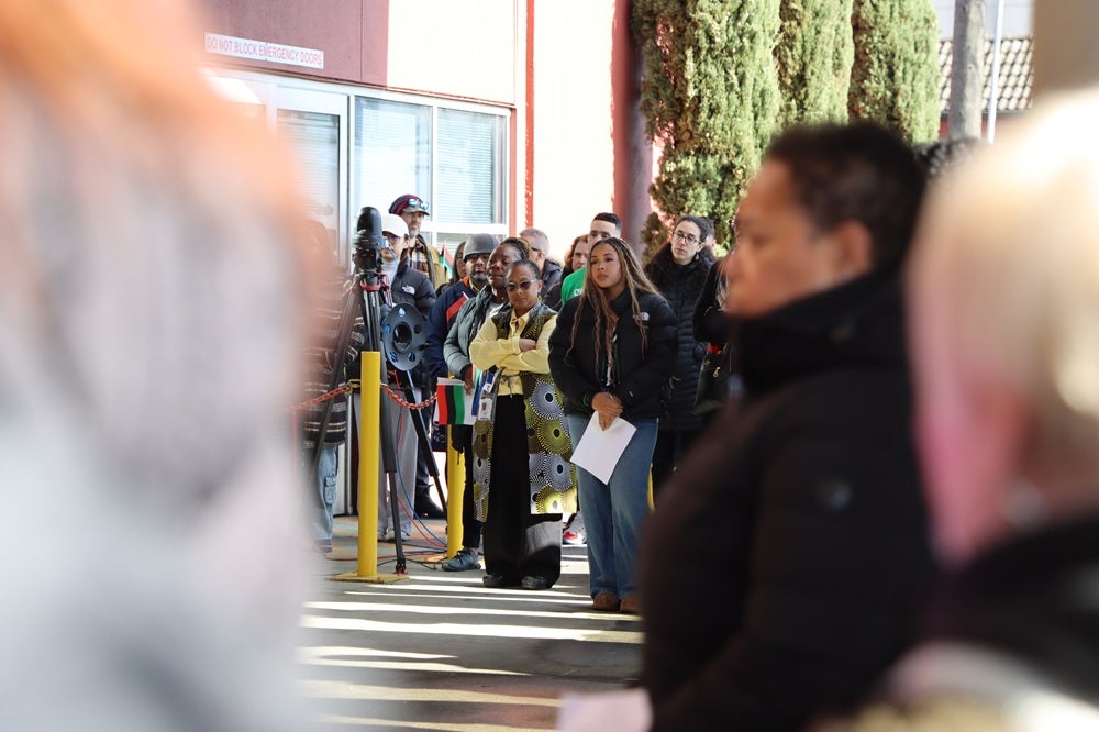 District staff listen during the Black History Month flag raising ceremony.