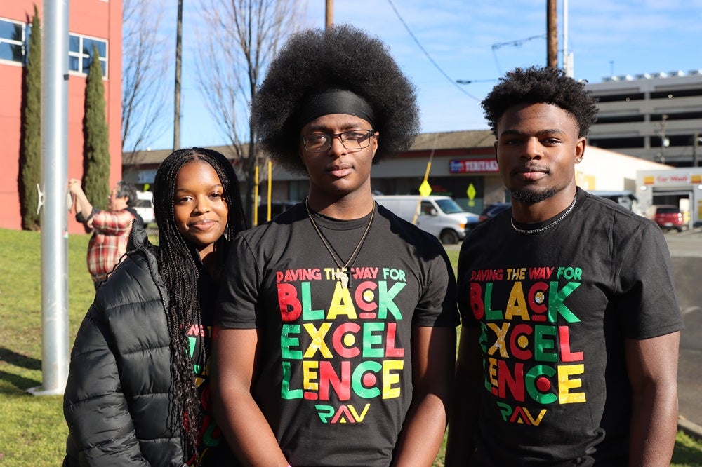 Black Student Union members Aida Starr, Oteko Mwamba, and Akeem Murph wearing "black excellence" t-shirts at black history month flag raising