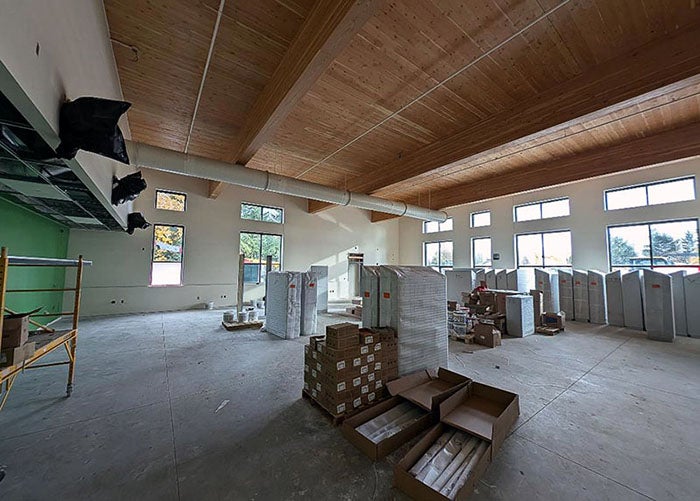 a large room under construction with a wood ceiling and one wall painted green