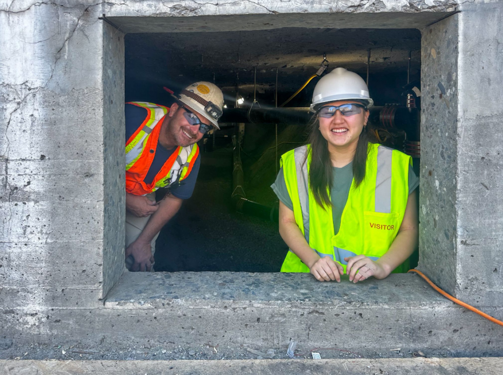 student peering out of concrete pour construction site