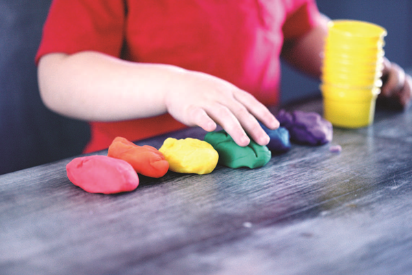 Preschool student playing with play dough