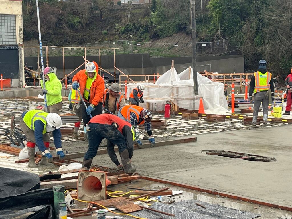 workers are smoothing concrete at a construction site