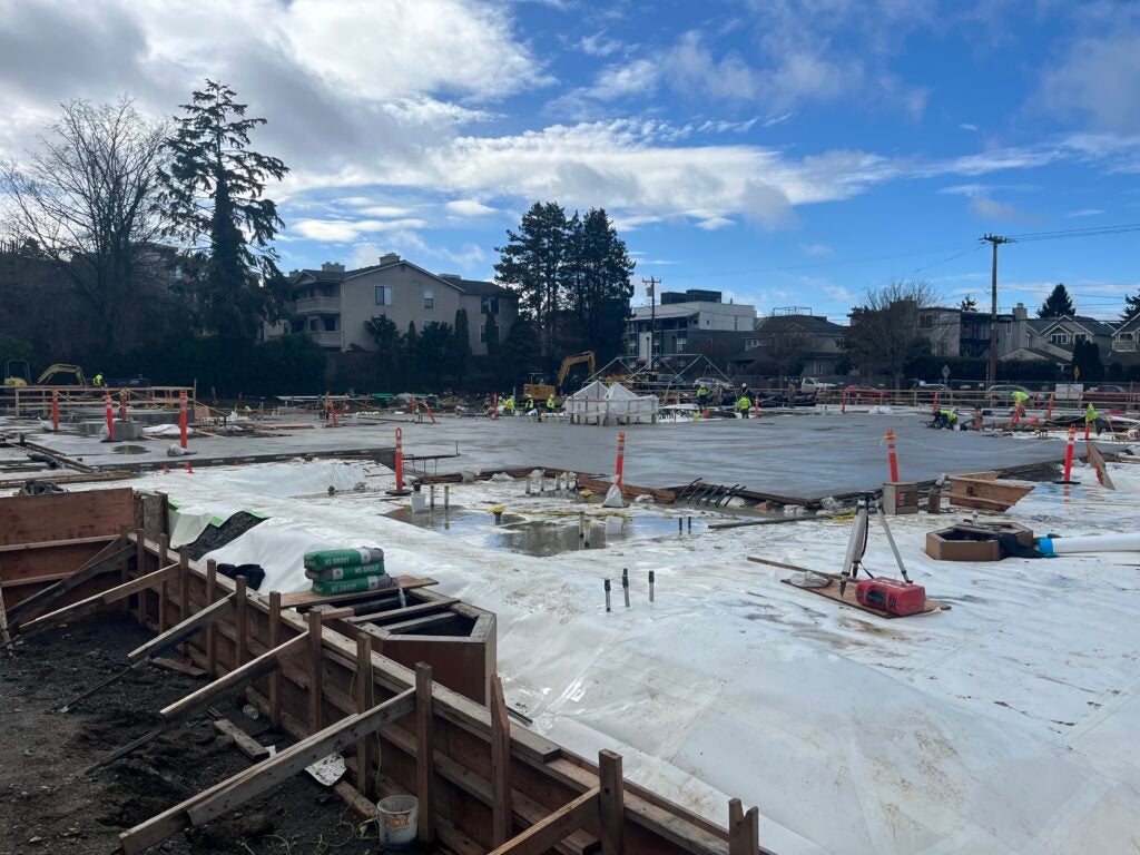 a work site has part of a concrete slab poured with another area ready for concrete