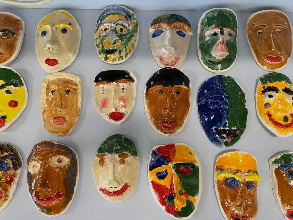 A picture of hand painted ceramic masks made by students.