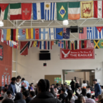 Auditorium with staff, students and overhead hanging flags from different contries.