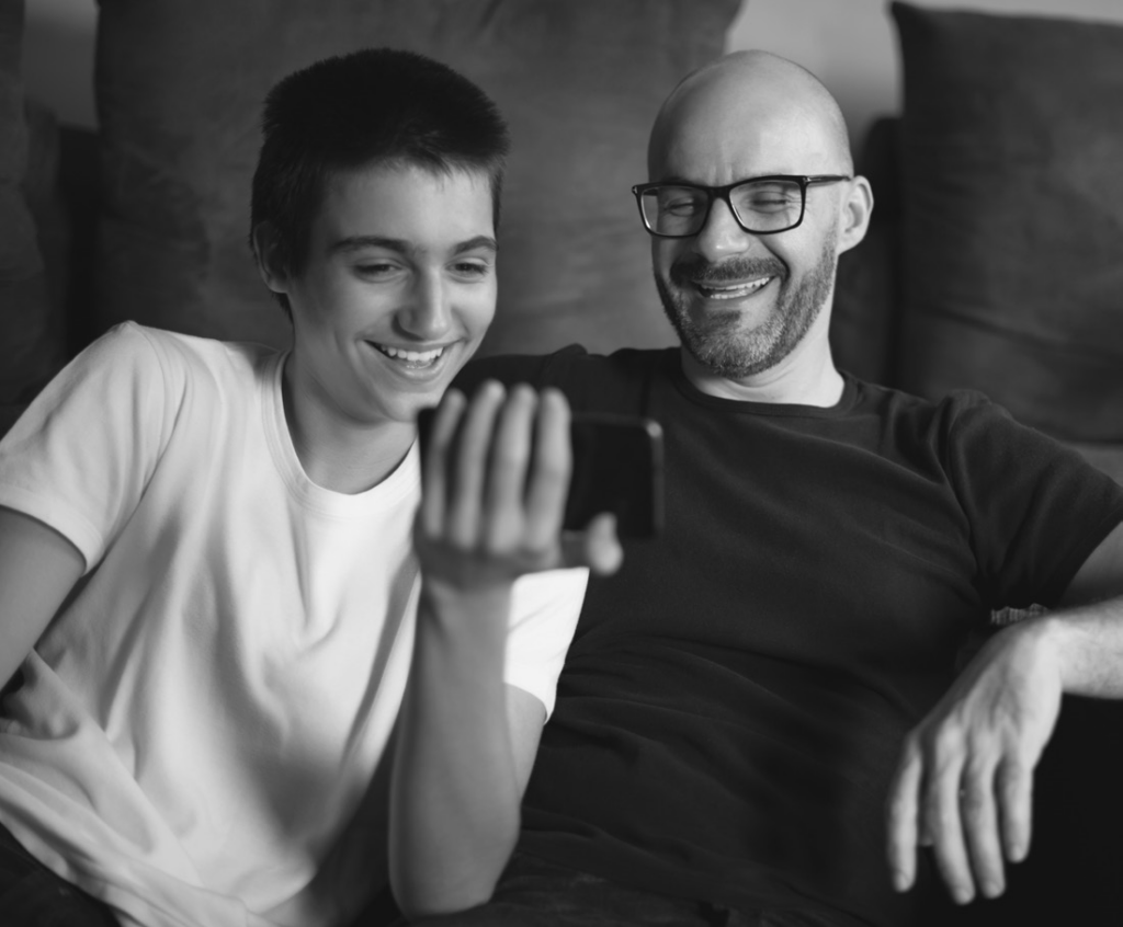 student and parent looking at a phone and smiling