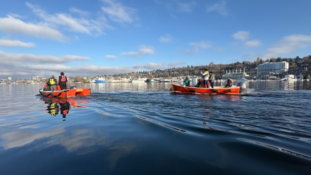 Two boats with students and instructors on lake union on sunny day